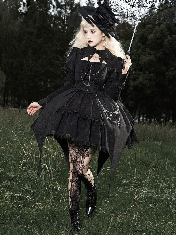 Person in a black gothic dress standing in a grassy field