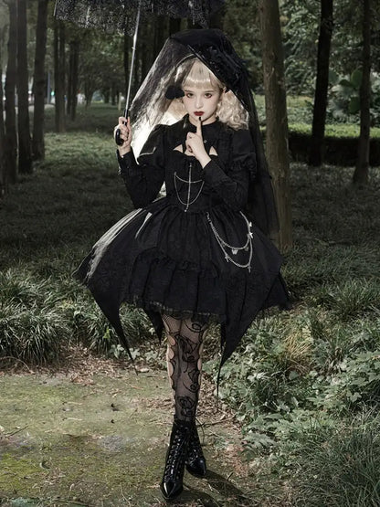 Person in a dark, gothic-style outfit with a veil walking through a forest.