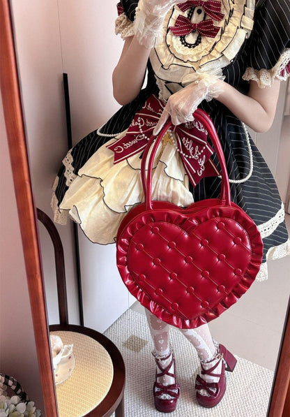 Person in a detailed outfit holding a red heart-shaped bag.