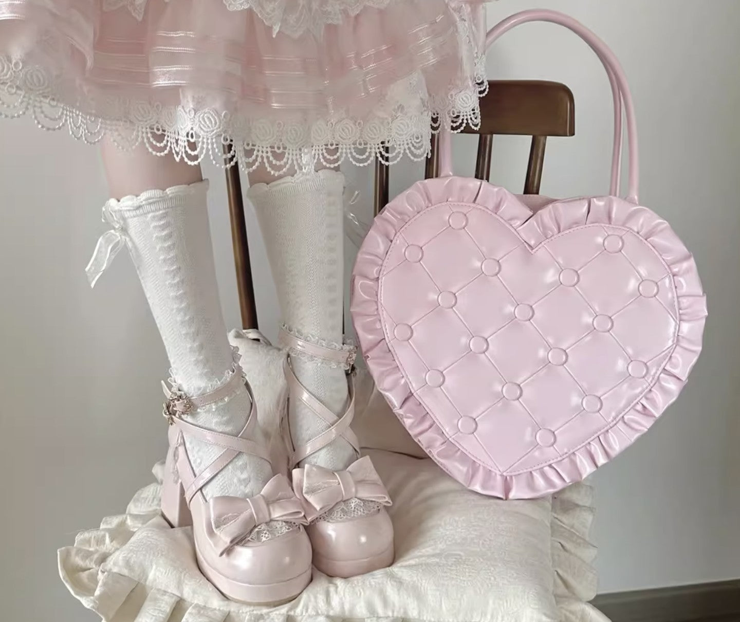 Pastel pink and white outfit with heart-shaped bag and lace details.