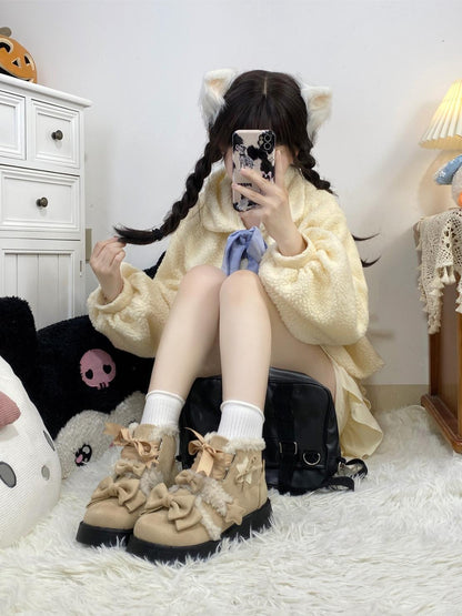 Person wearing a yellow sweater and beige boots with bows, sitting on a white rug.