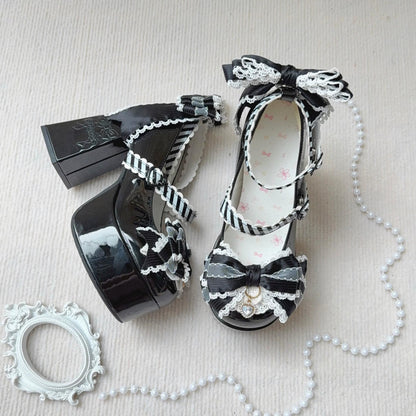 Black high-heeled shoes with decorative bows and ribbons on a light background