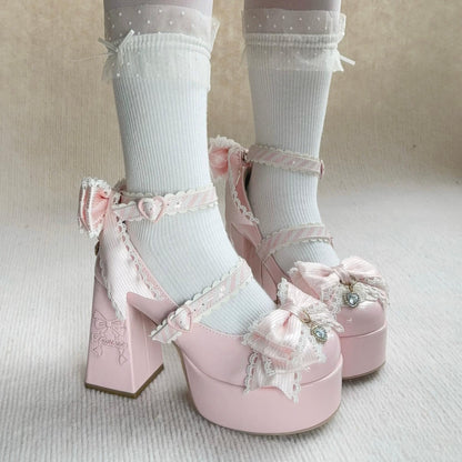 Pink platform shoes with decorative bows worn with white socks on a neutral background