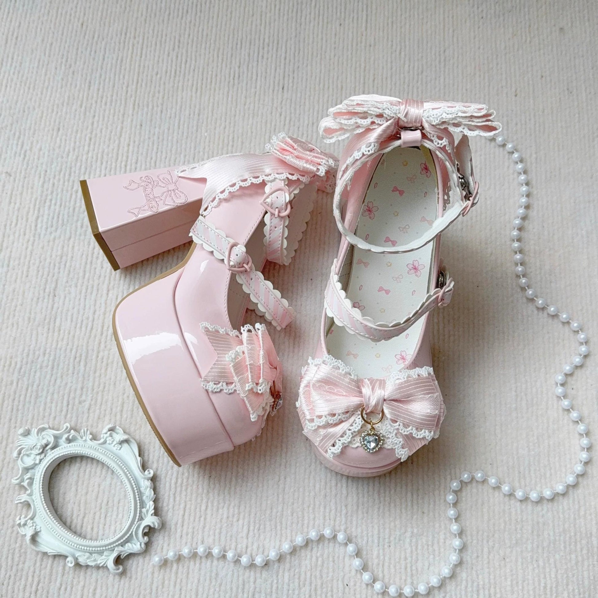 Pink women shoes with decorative bows and ribbons on a light background