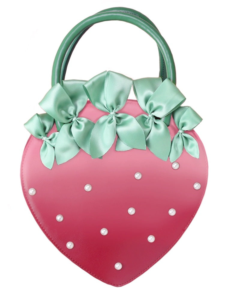 Pink strawberry-shaped handbag with green bows and white pearls on a white background