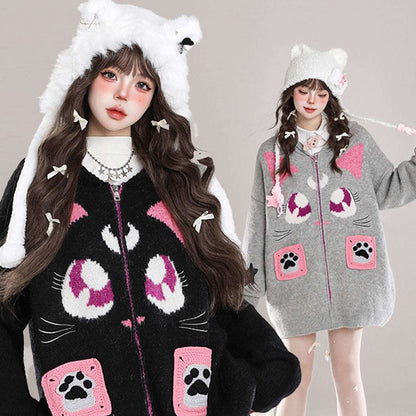 Two people wearing cat-themed hoodies with paw prints and ears on a plain background.