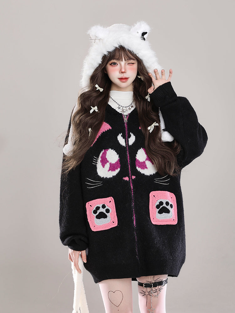 Person wearing a black hoodie with cat-themed designs on a plain background