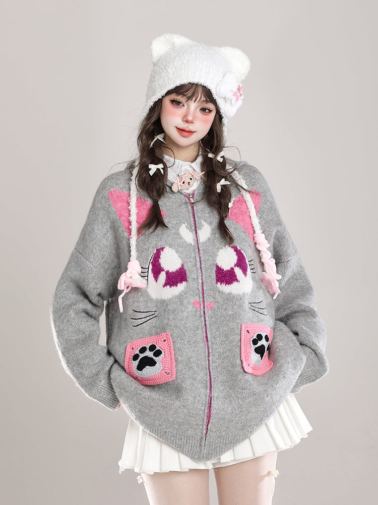 Person wearing a gray hoodie with cat-themed design on a plain background