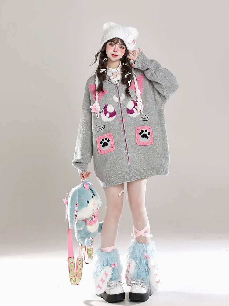 Person wearing a gray hoodie with cartoon designs, holding a plush toy, on a plain background