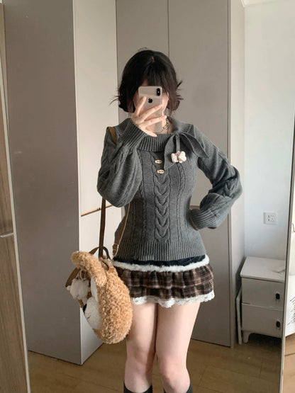 Person wearing a gray cable knit sweater and brown skirt with white lace trim, holding a beige bag.