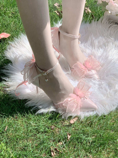 Pink ballet shoes with ruffles on a fluffy white rug and grass background