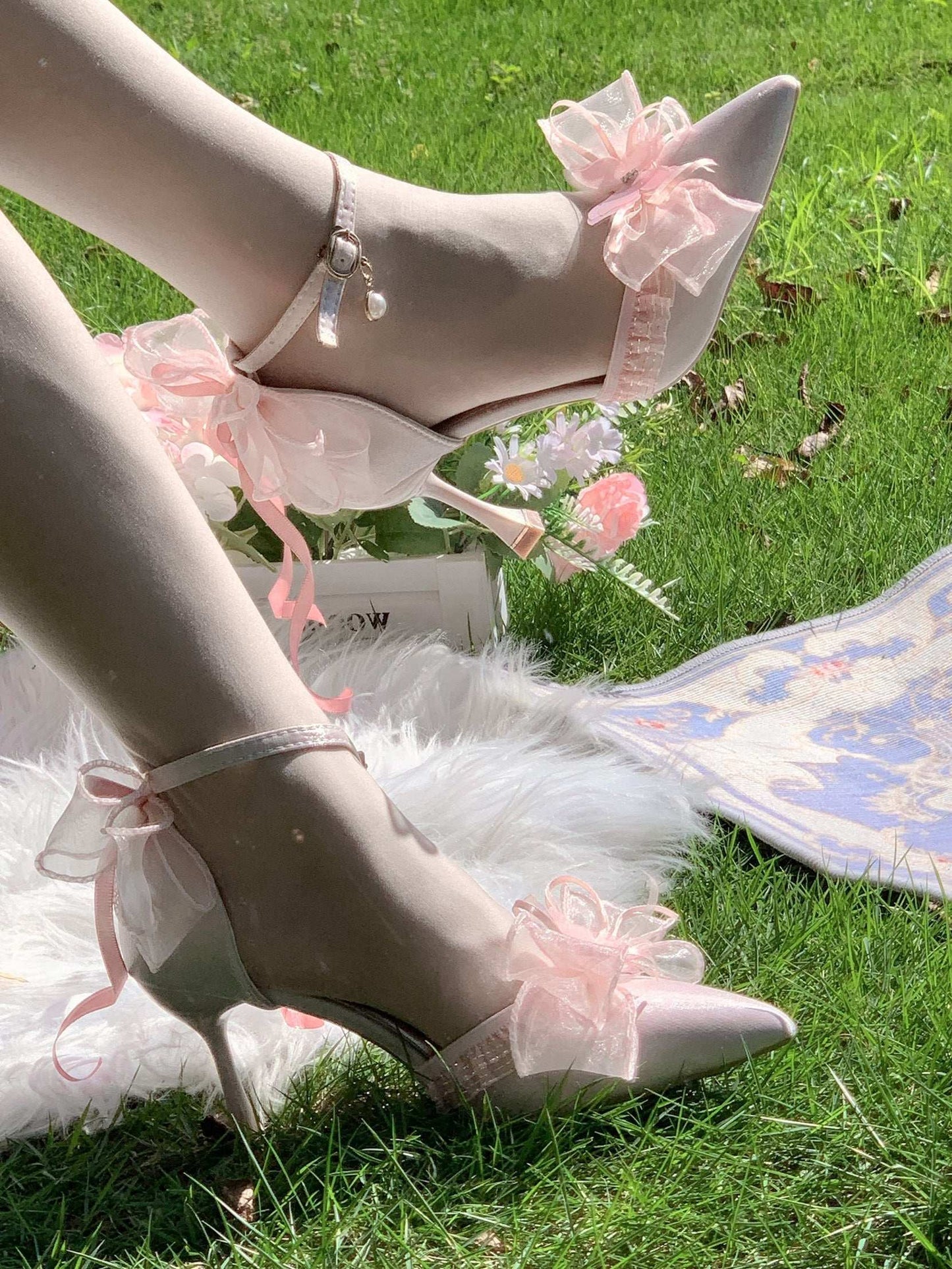 High-heeled shoes with floral decorations on a grassy background