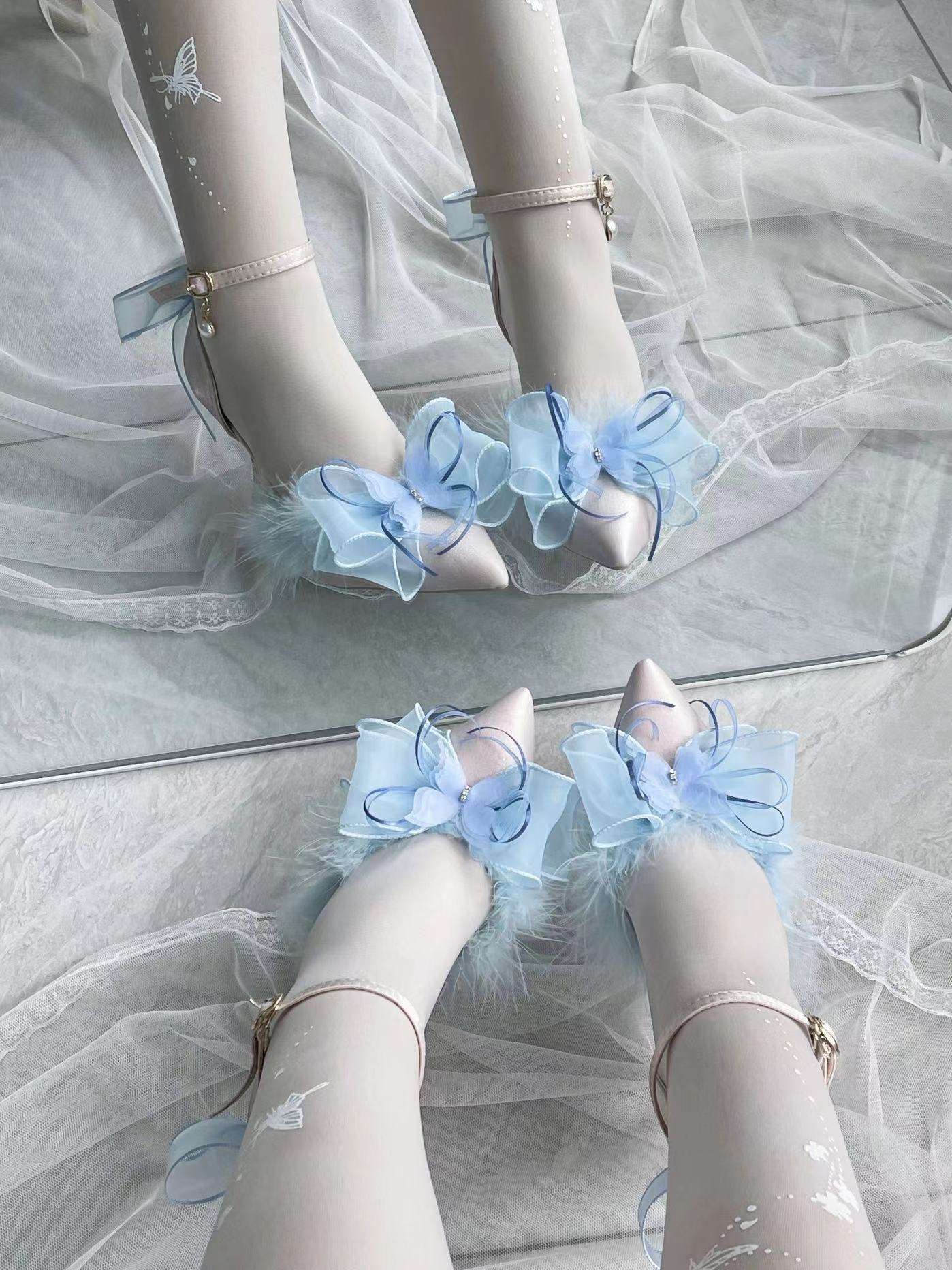 High-heeled shoes with light blue ruffled details on a white background
