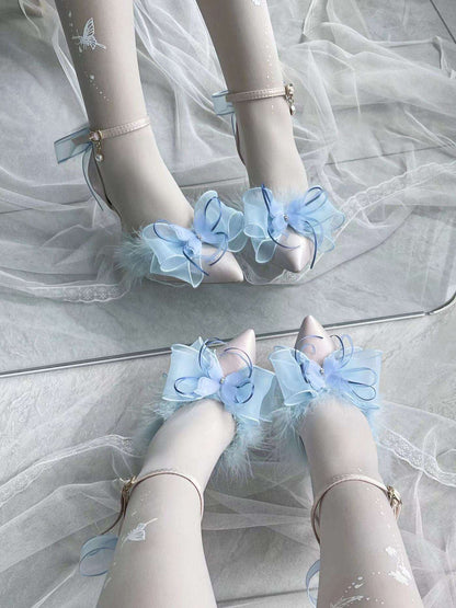 High-heeled shoes with light blue ruffled details on a white background