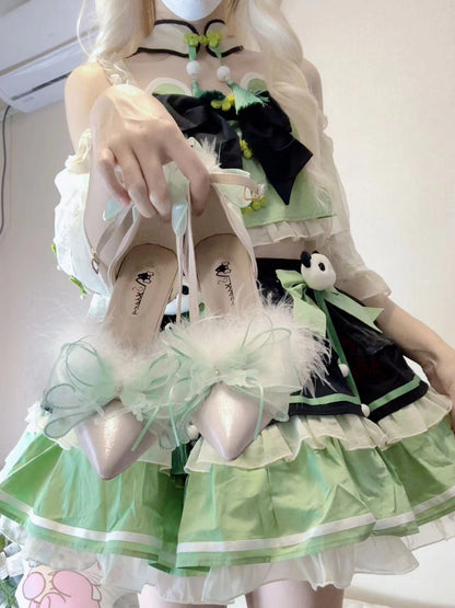 Person wearing a green and black dress with white shoes, standing against a plain background.