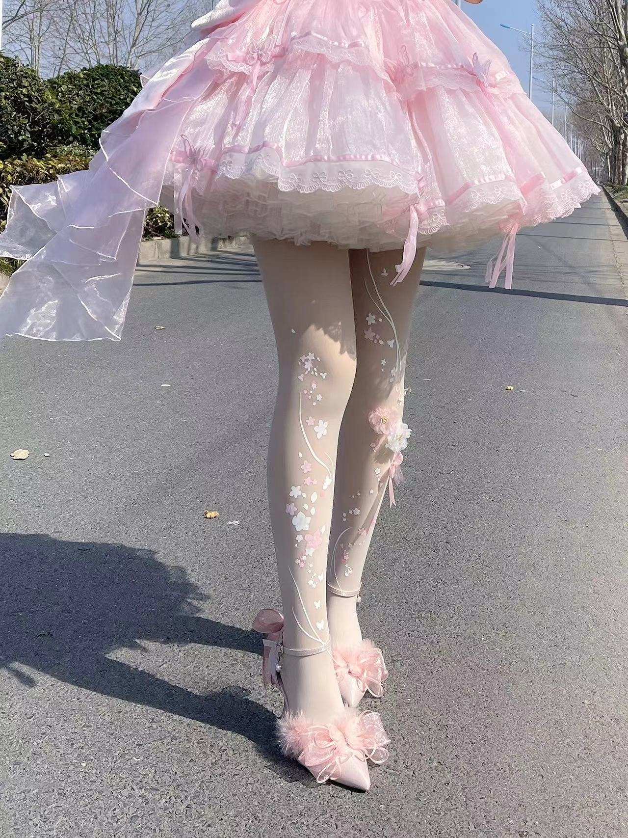 Person wearing a pink skirt and tights with floral designs on a road.