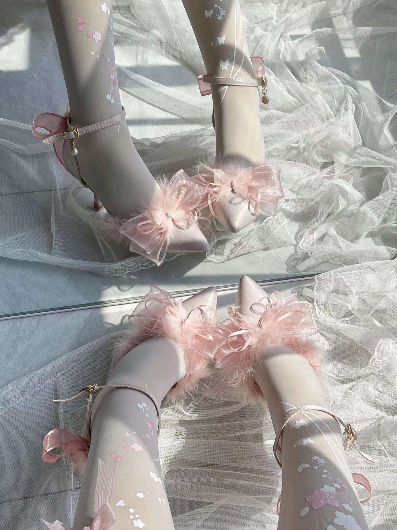 Pink high-heeled shoes with decorative bows on a white background