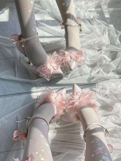 Pink high-heeled shoes with decorative bows on a white background