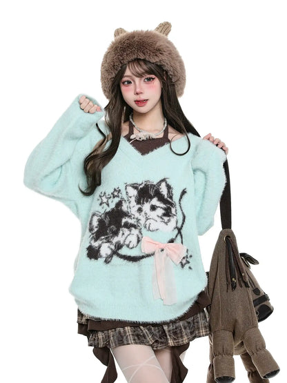 Woman wearing a light blue sweater with a cat design, brown hat, and plaid skirt on a white background.