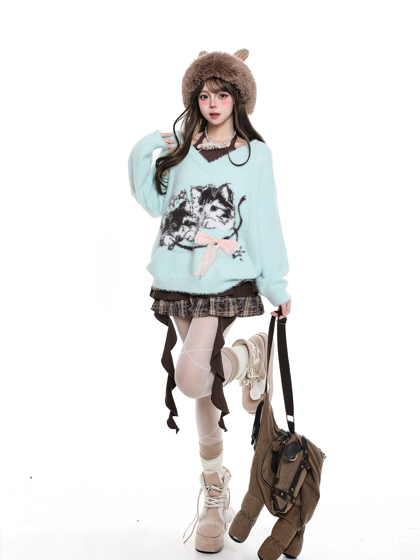 Person wearing a light blue sweater with a dog design, plaid skirt, and brown boots on a white background.