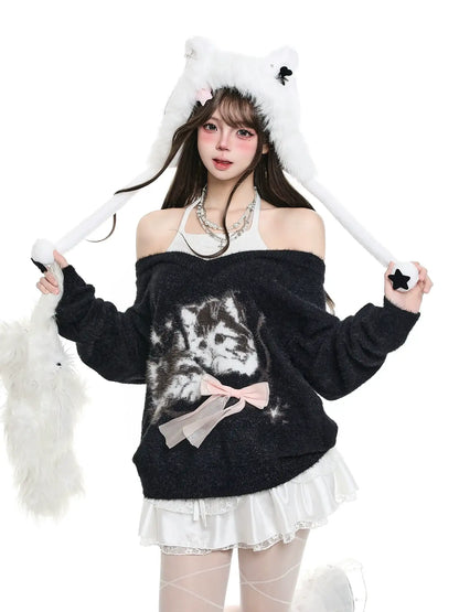 Person wearing a black off-shoulder sweater with a cat design and white fluffy accessories on a white background