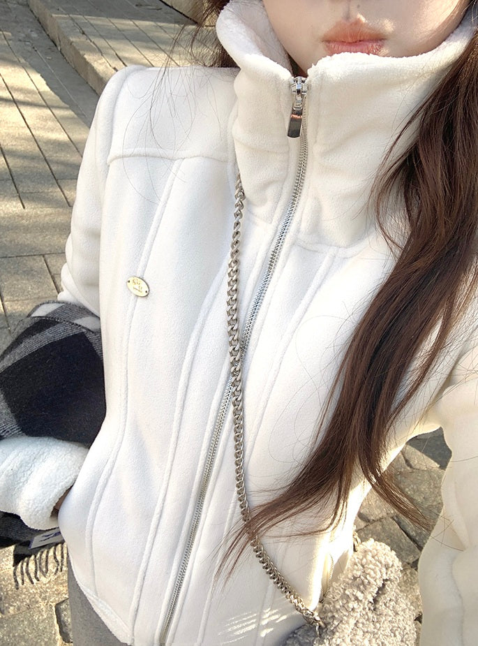 Close-up of a person wearing a white puffer vest with a chain detail.