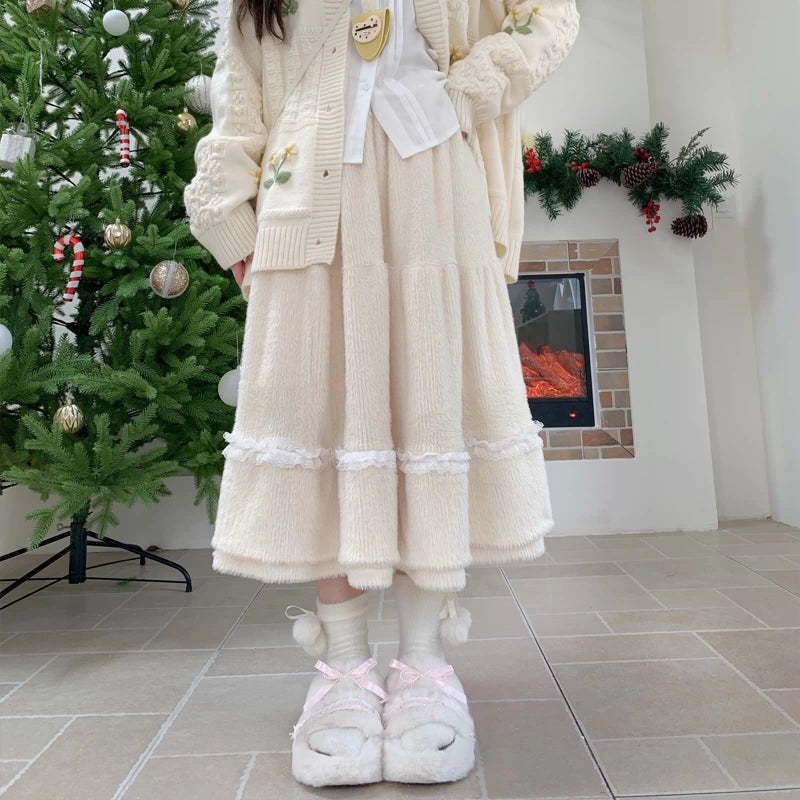 Person wearing a long cream-colored dress with floral patterns in a festive room with a Christmas tree and fireplace.