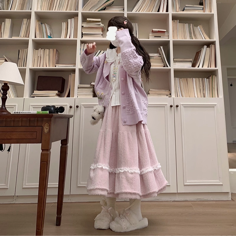 Person wearing a pink outfit standing in front of a bookshelf