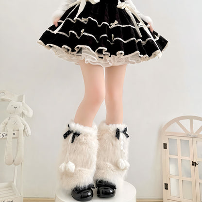 Person wearing a black and white outfit with fluffy white boots in a room setting.
