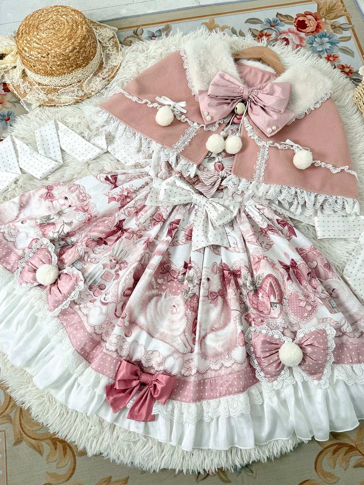 Delicate pink and white dress with floral patterns and decorative bows on a patterned surface.