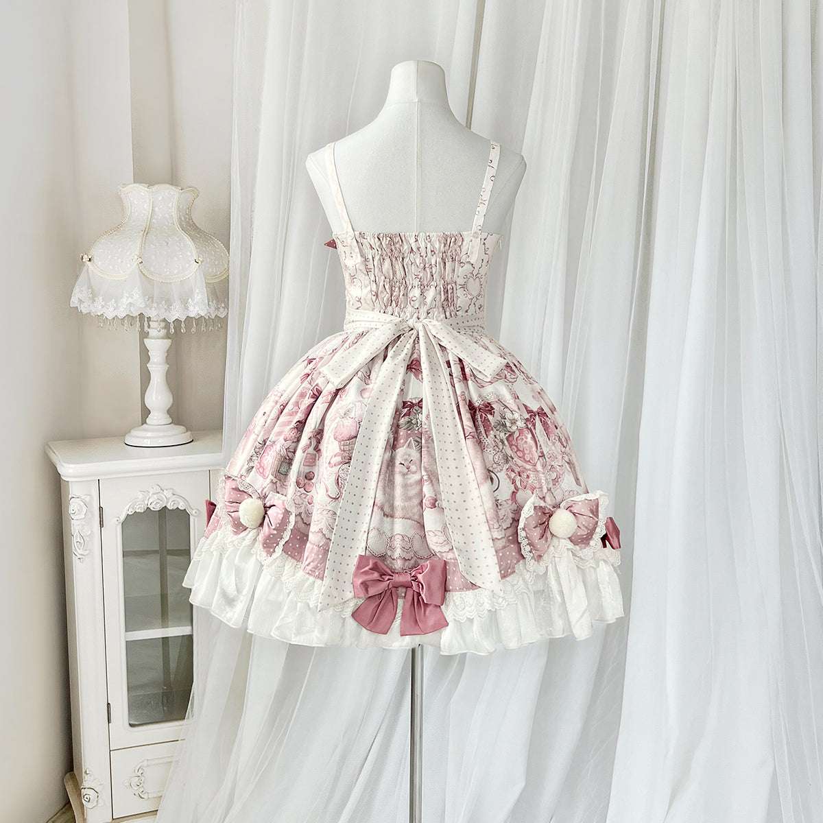 Pink and white floral dress on a mannequin against a white curtain background