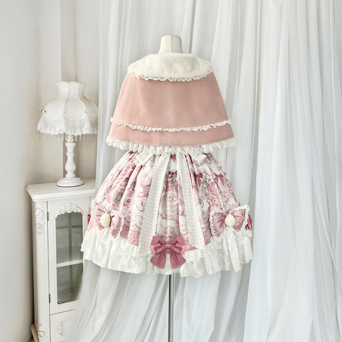 Lolita-style dress on a mannequin against a white curtain background