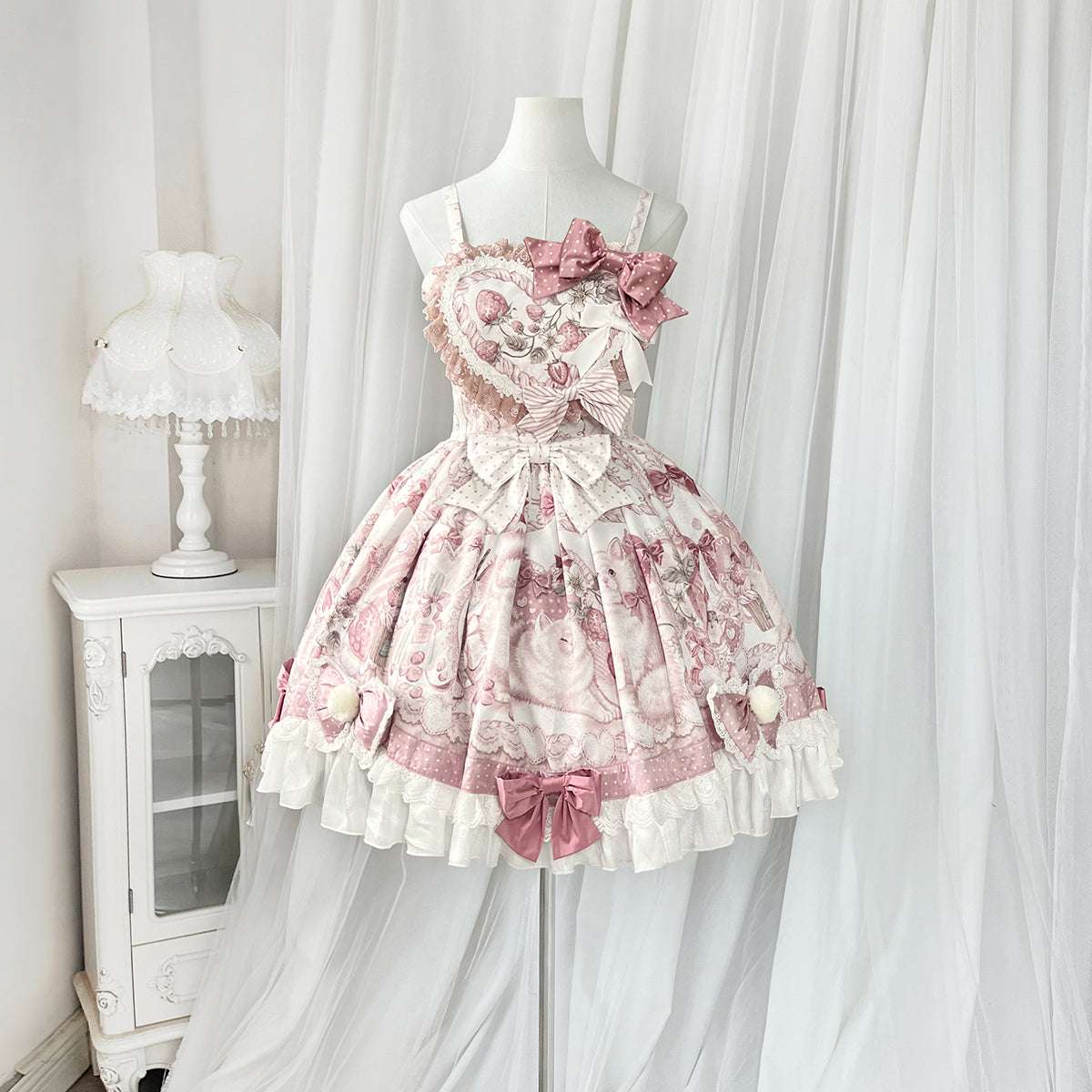 Pink floral dress on a mannequin against a white curtain background