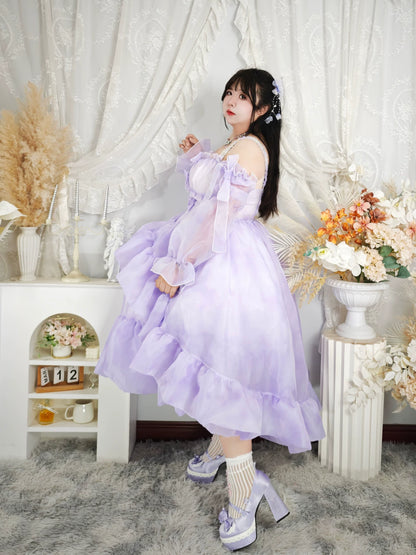Woman in a lavender dress standing in a decorated room with flowers and decor.