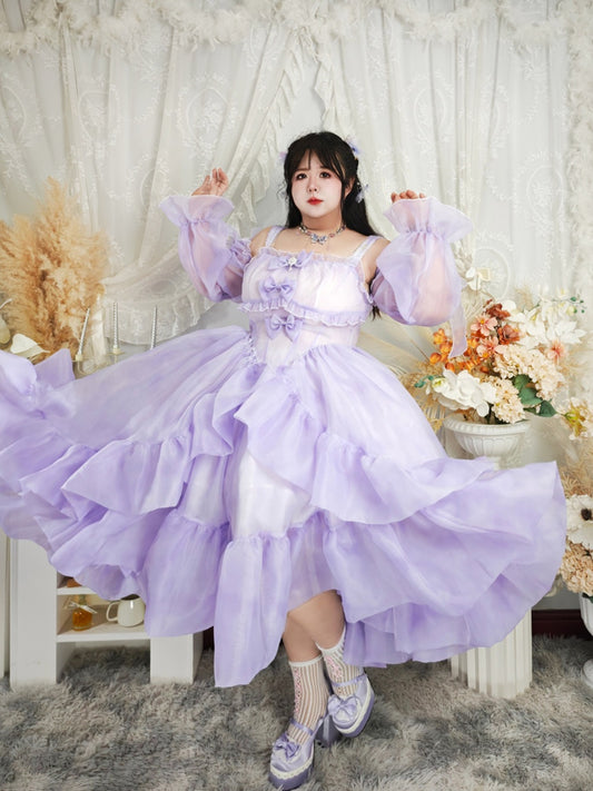 Person wearing a purple dress with ruffled sleeves and skirt in a decorative setting.