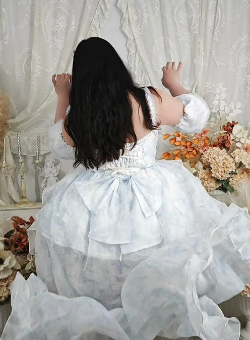 A girl in a white dress with floral decorations and a white curtain background