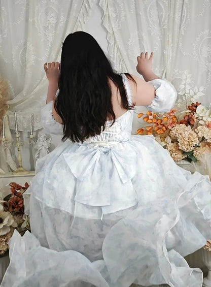 A girl in a white dress with floral decorations and a white curtain background