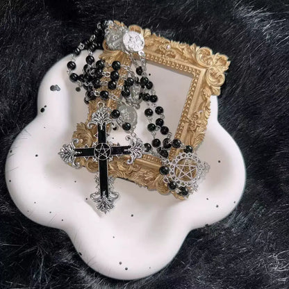 Decorative frame with black and gold rosary on a white dish against a dark fur background