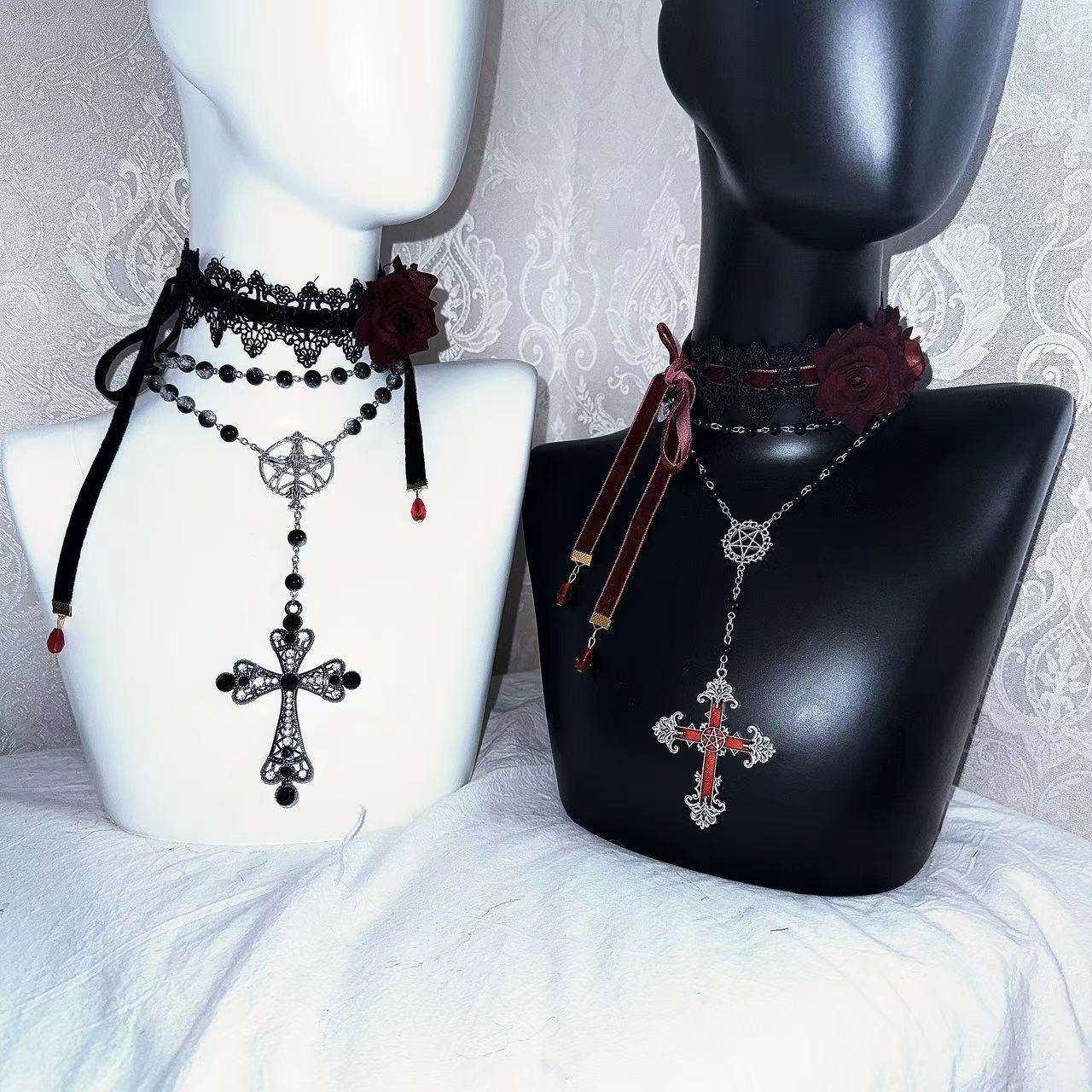 Two necklaces with crosses on mannequin busts against a decorative background