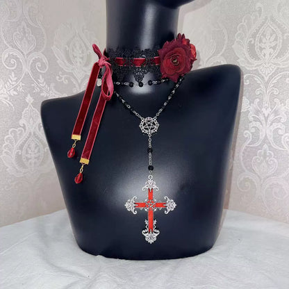 Necklace with red cross pendant on a black mannequin bust against a decorative wall.