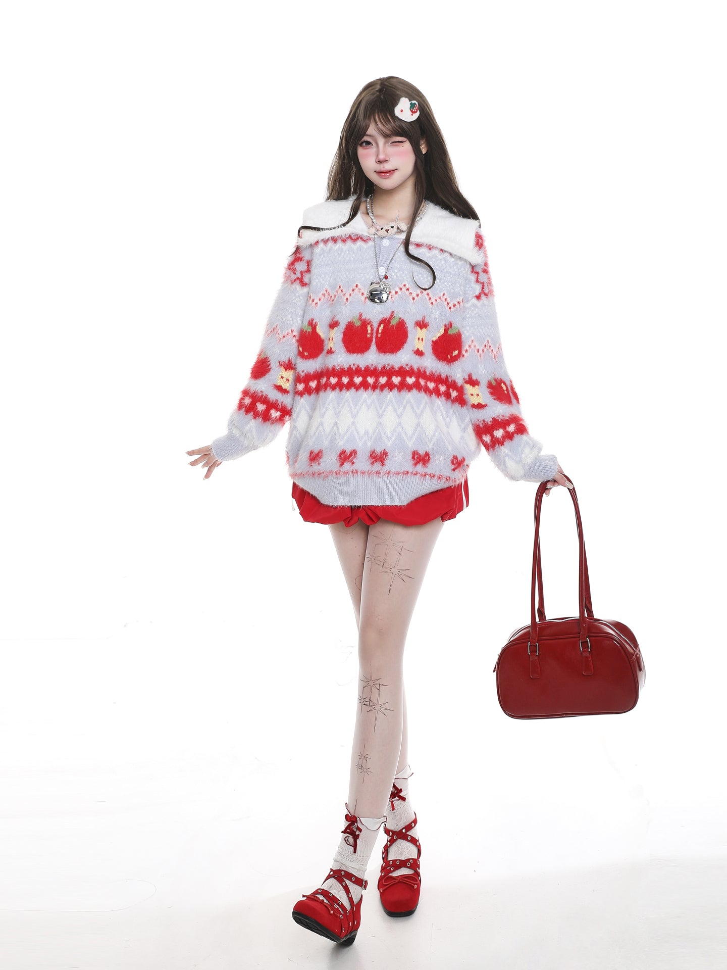 Person wearing a red and white patterned sweater with matching shorts, holding a red handbag on a white background.