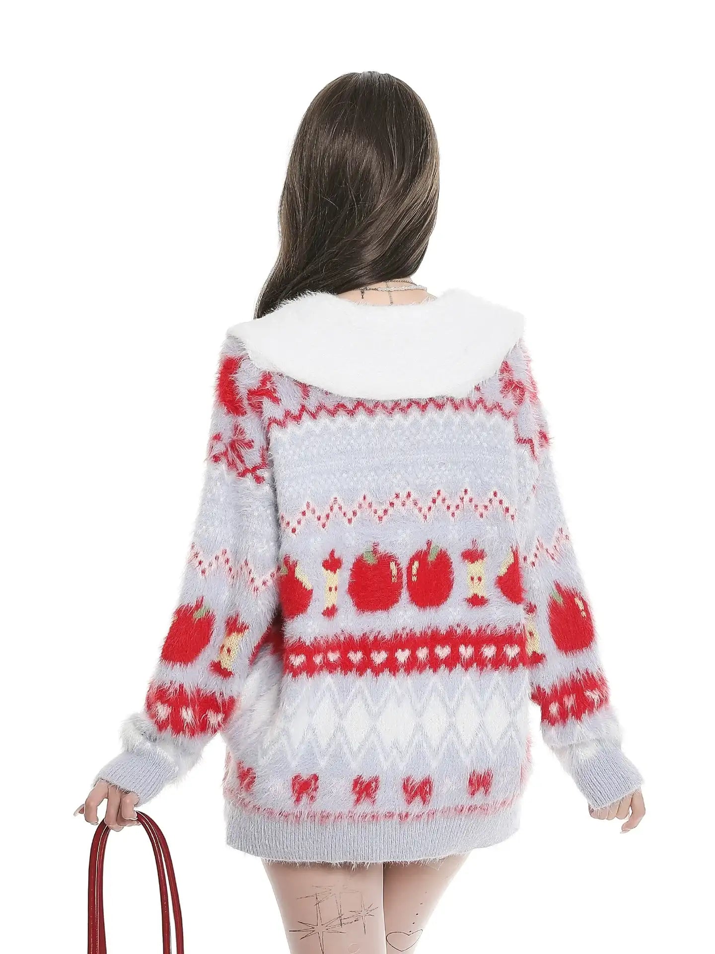Person wearing a patterned sweater with red and white design on a white background