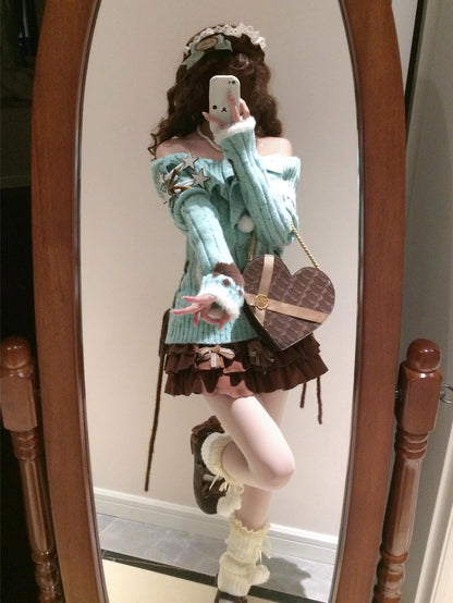 Person taking a mirror selfie wearing a light blue sweater and brown skirt.