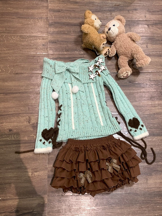 Women outfit with teal sweater and brown skirt on a wooden surface, accompanied by teddy bears.