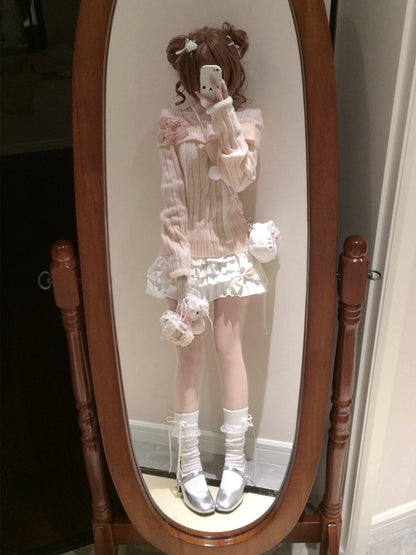 Person wearing a pink outfit with white accents standing in front of a mirror.