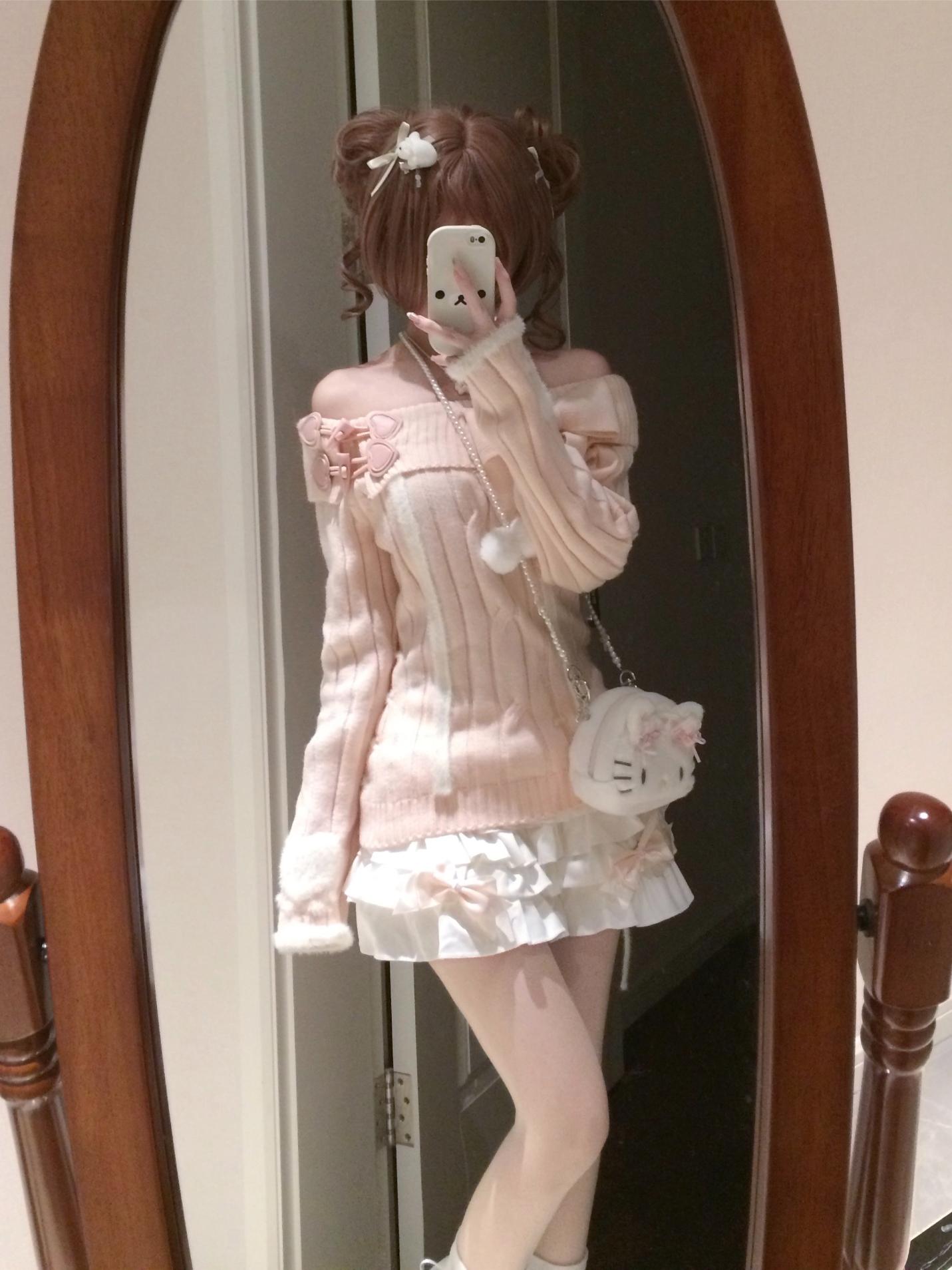 Person wearing a pink outfit with a white dress and holding a phone, standing in front of a mirror.
