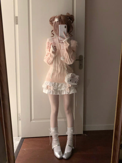 Person taking a mirror selfie wearing a pastel outfit with a white door in the background.