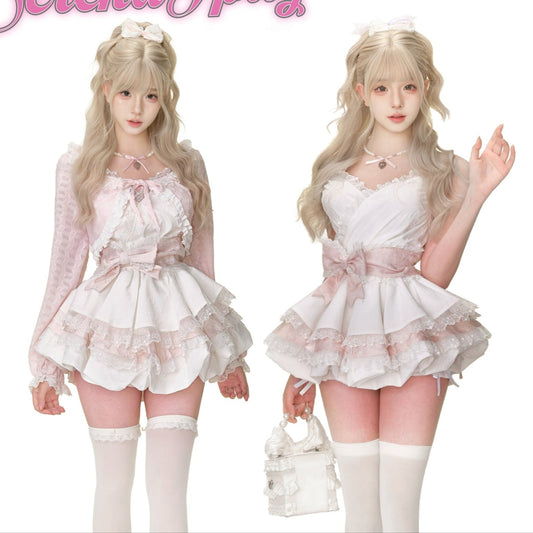 Two women in matching white outfits with pink accents, standing on a pink surface.