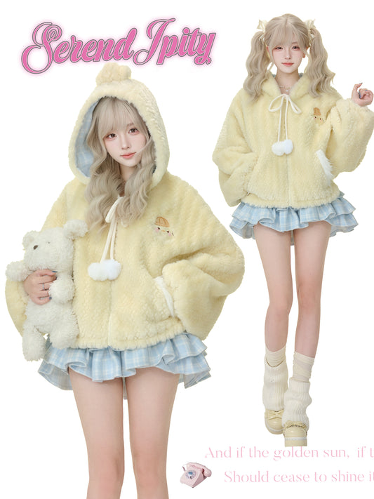 Two people wearing matching yellow hoodies with fluffy textures, holding plush toys, on a white background.