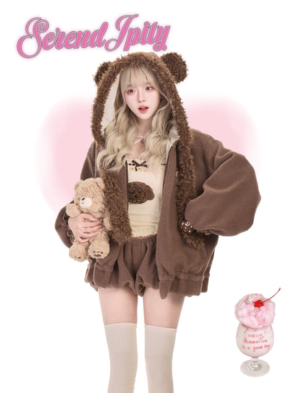 Person wearing a brown bear-themed outfit with a teddy bear, holding a pink drink with a cherry on top, against a white background.